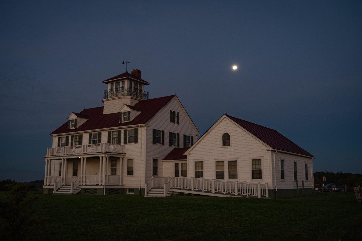 A view of a home during the evening with the moon on the sky